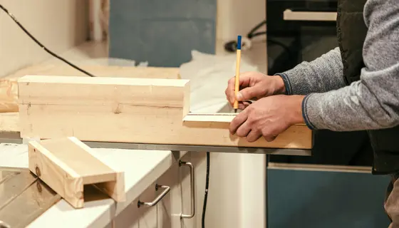 A carpenter is measuring a piece of wood.